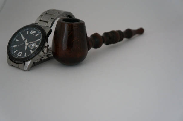 Tobacco pipe or smoking pipe on a wooden table