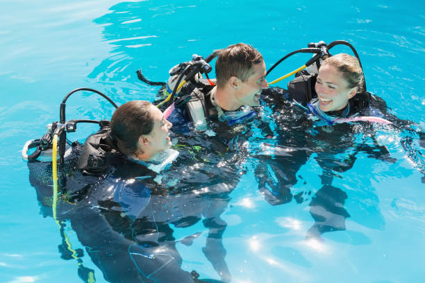istock Smiling friends on scuba training in swimming pool 691418812
