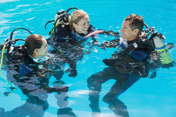 istock Smiling friends on scuba training in swimming pool 691418894