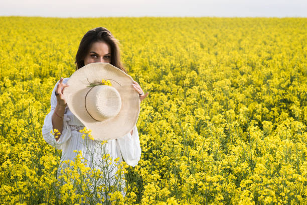 istock Woman hiding her mouth with straw hat during spring day in a meadow. 691419284