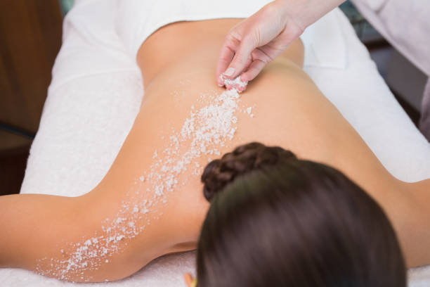 istock Beauty therapist pouring salt scrub on womans back 691419934