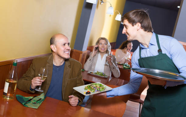 istock waiter serving senior male customer in cafe 691421900