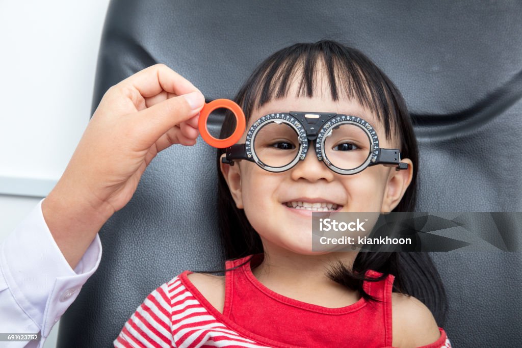 Asian Little Chinese Girl Doing Eyes Examination Asian Little Chinese Girl Doing Eyes Examination at An Optical Shop Child Stock Photo