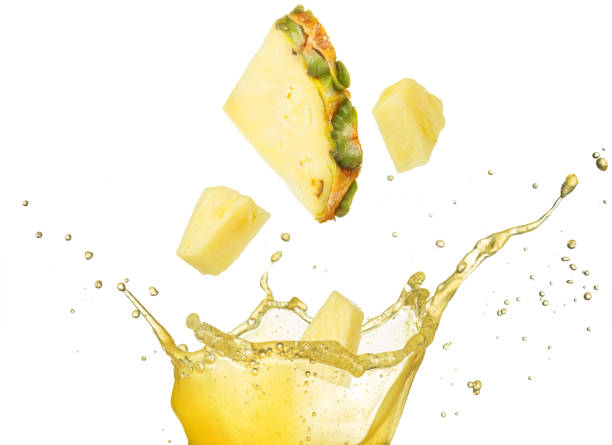 pineapple falling into juice stock photo