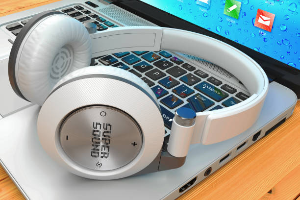 istock Wireless headphone and laptop on wooden table 691430110