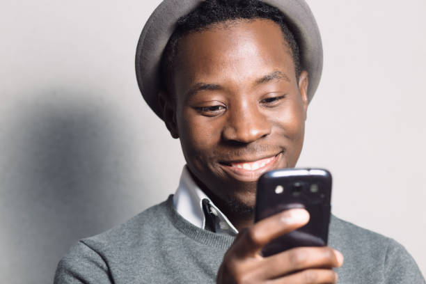 istock African american man using mobile phone near grey wall 691433482