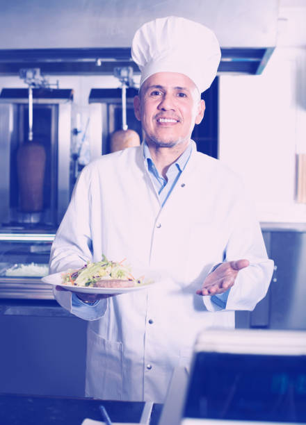 istock mature chef in fast food restaurant 691436596