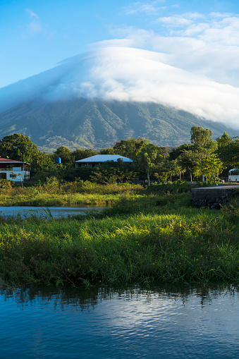 Morning view from Lake Nicaragua to island Ometepe and volcano Conception with white clouds on it. Nicaragua, Central America. Volcano Conception is one of the most perfectly shaped volcanos of the Americas and the second higest, 1610 m in Nicaraqua and is active volcano with last activity in March 2010.