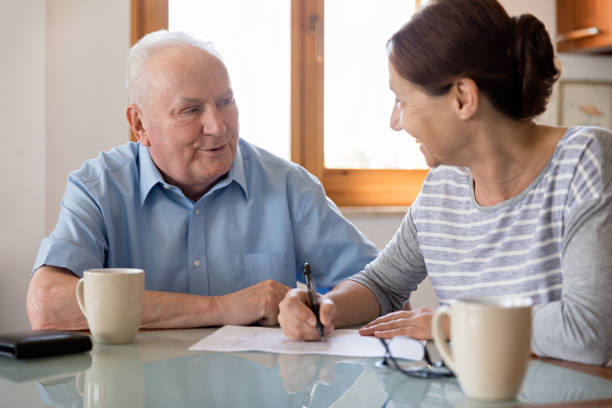 istock Female caregiver helping senior man 691448906