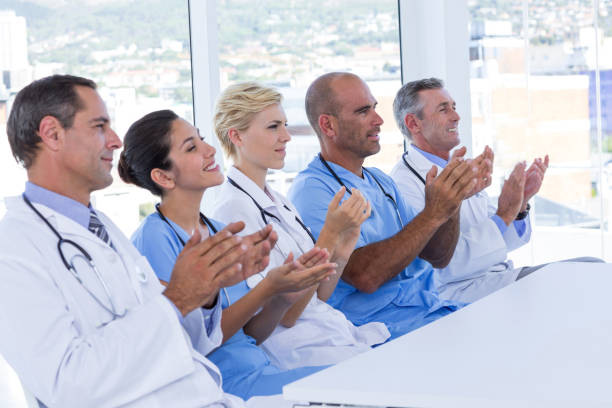 istock Team of doctors applauding during meeting 691453060