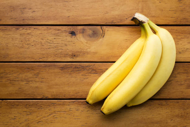 istock Yellow banana on wooden table 691457384