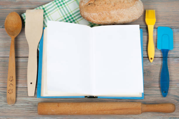 istock Open recipe book on wooden background, spoon, rolling pin , green checkered tablecloth 691465054
