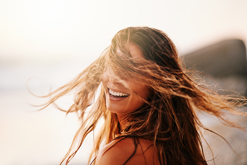 Shot of a beautiful and carefree young woman enjoying a day at the beach