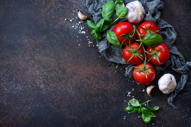 ingredients for cooking - garlic, tomatoes, basil, spices and olive oil on the kitchen table. food background. copy space. - 7070 imagens e fotografias de stock