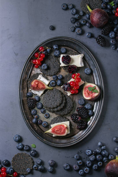 istock Black crackers with cheese and berries 691478924
