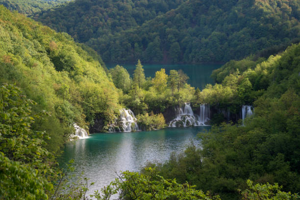 Waterfalls and lakes among green mountains Waterfalls and lakes among lush foliage. Scene in Plitvice Lakes National Park. ivory coast landscape stock pictures, royalty-free photos & images
