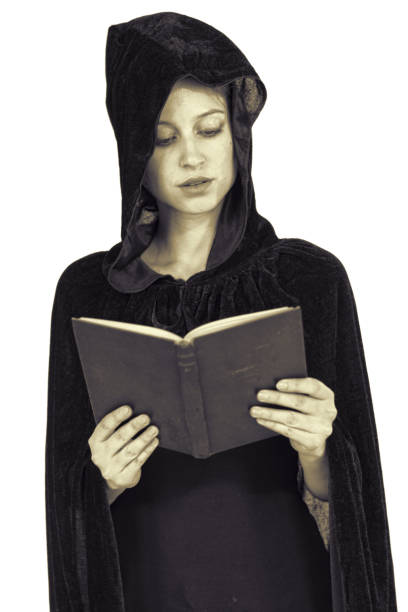 istock Hooded widow in black robe reading book cross-processed 691490000