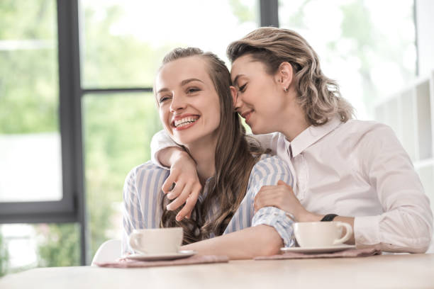 istock young smiling caucasian girlfriends drinking coffee and embracing at cafe 691490390