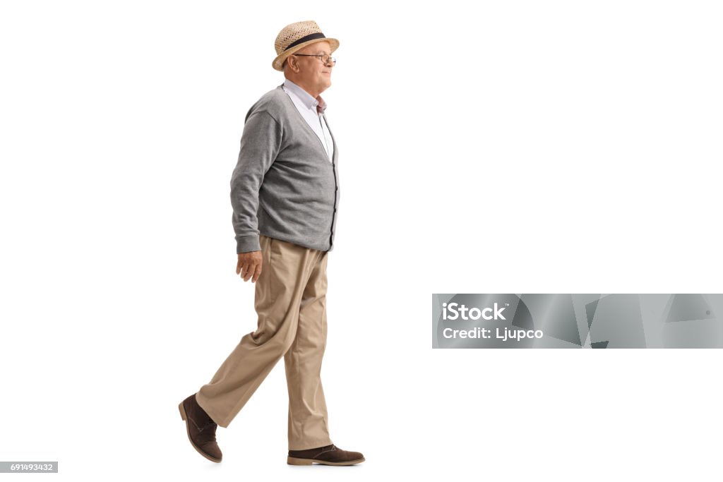 Elderly man walking and smiling Full length profile shot of an elderly man walking and smiling isolated on white background Walking Stock Photo