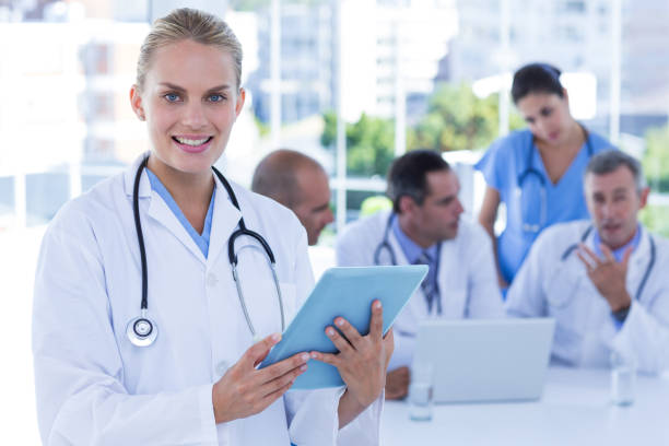 istock Smiling female doctor looking at clipboard while her colleagues works 691493986