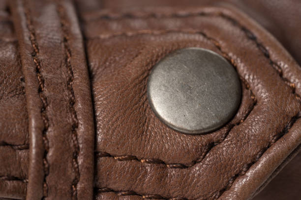 istock Brown leather jacket shoulder metal clasp button. Macro leather shoulder detail 691496782
