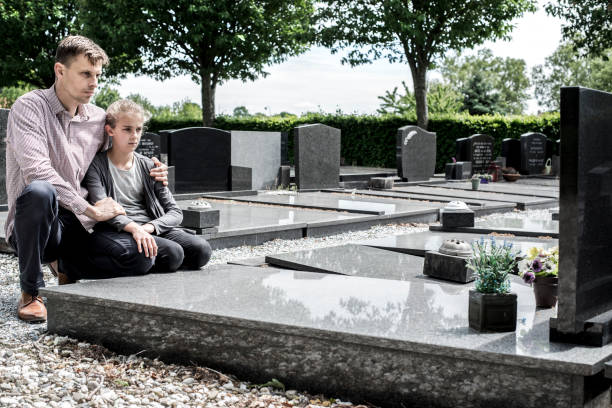 father and daughter visiting grave - cemetery child mourner death imagens e fotografias de stock