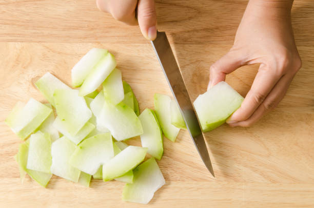 istock Chef cutting wax gourd on wooden board 691500270