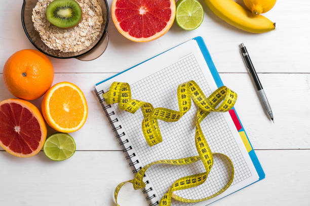 istock Healthy breakfast with oatmeal, fresh fruits and notebook on rustic wooden table 691508582