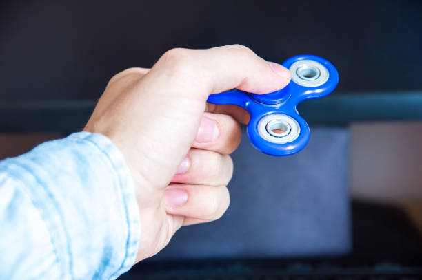 istock Man's hand holds a spinner on the background of a personal computer close-up 691509072