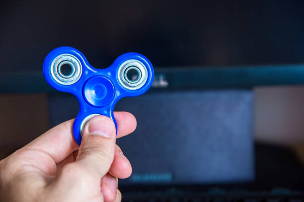 istock Man's hand holds a spinner on the background of a personal computer close-up 691510766