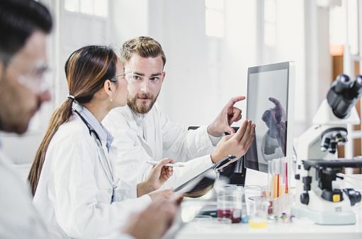 Scientists Looking at Computer Monitor and Discussing