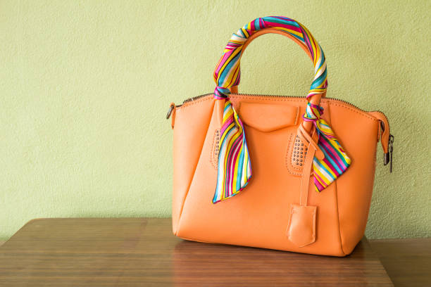 istock orange purse on wood background, luxury women accessory 691512380