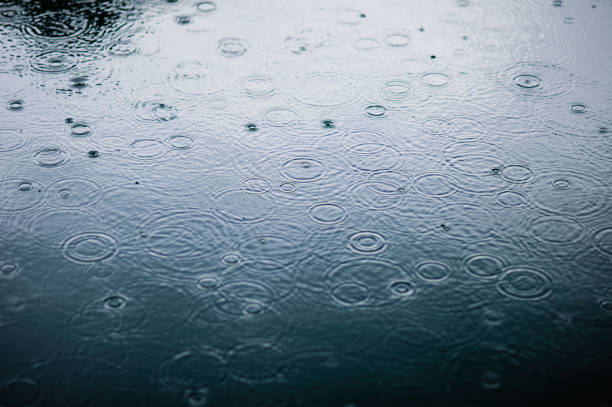 gotas de lluvia sobre la superficie del agua azul con sombra graduado de sombra - puddle condensation water drop fotografías e imágenes de stock