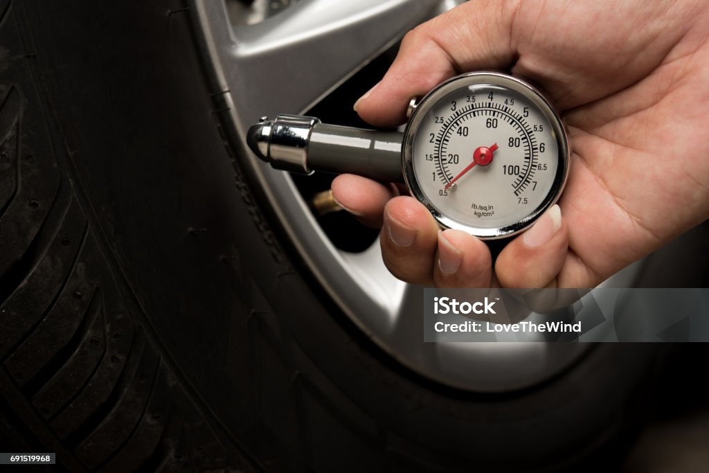 Hand of man holding gauge measurement pressure checking tire of car transportation knowledge Tire - Vehicle Part Stock Photo