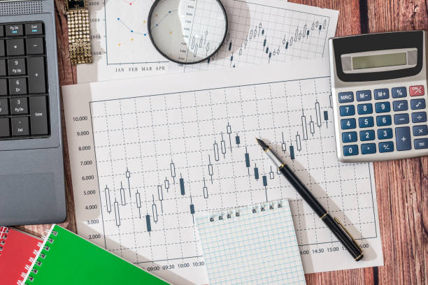 istock laptop, stock market data, with calculator and pen 691524422