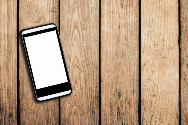istock cell phone on wooden table texture background with space. 691524490