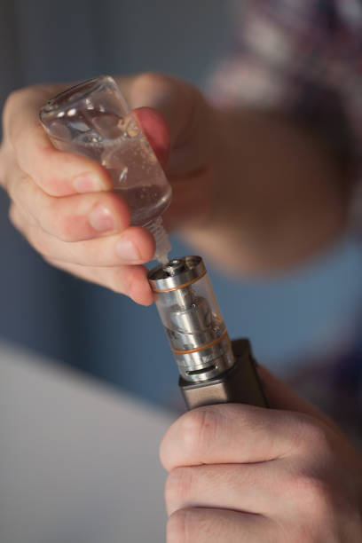 istock The guy runs in the electronic cigarette liquid. vape. 691528264