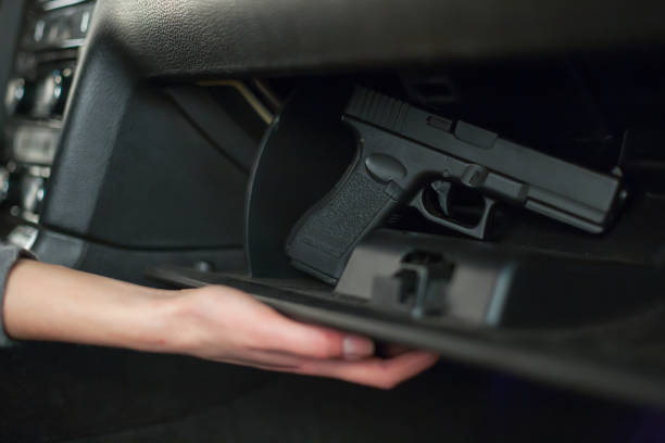 The female hand pulls out a gun from the glove box in the car. The female hand pulls out a gun from the glove box in the car glove box stock pictures, royalty-free photos & images