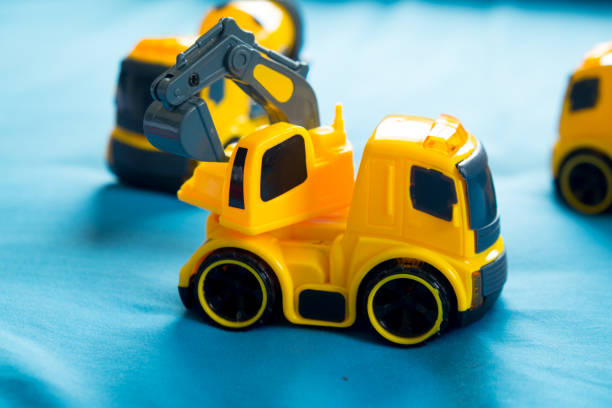 istock Children's toy yellow tractor on blue background 691537546
