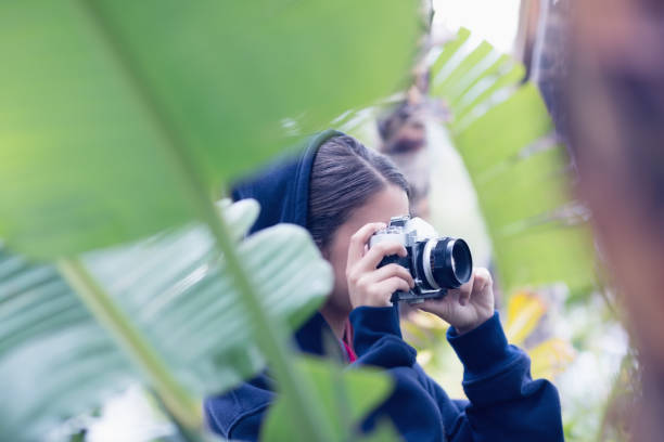 istock Young woman taking a picture in a forest 691537694