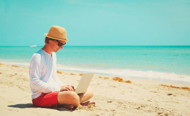 istock man working on laptop at tropical beach 691544952