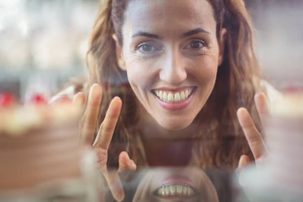istock Pretty brunette looking at camera through the glass 691547488