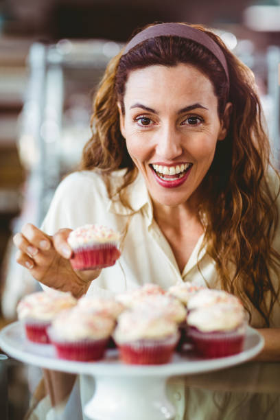 istock Pretty brunette smiling at camera and holding cake 691547678