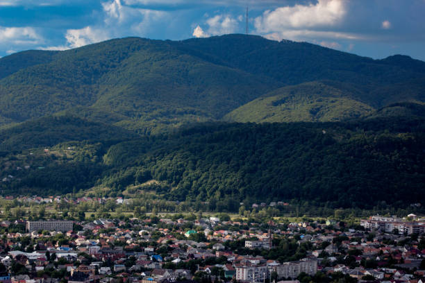 little town on a plain surrounded by mountains green hills. summer sunny landscape. view from the mountain