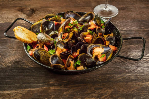 istock Skillet of marinara mussels on rustic background with copyspace 691554424
