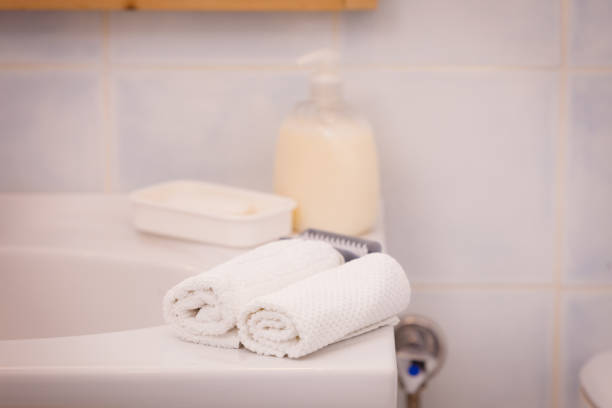 istock Two towels, soap in bottle with pump on sink 691559814