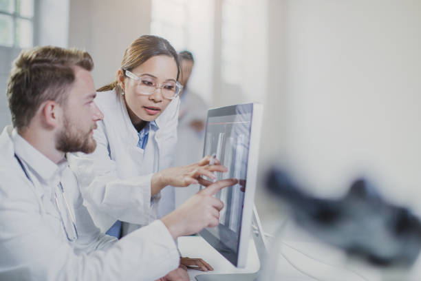 istock Doctors Discussing and Pointing at X-ray Images 691565886