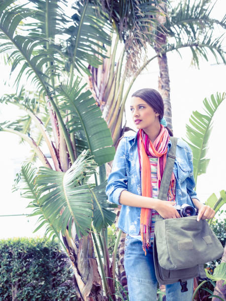 istock Young woman taking camera from her bag outside 691566718