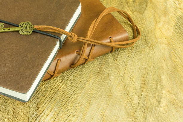 istock Notebooks in different colors with a key on a wooden table 691569824