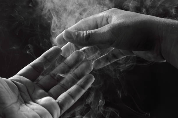 Abstract monochrome image of hands and smoke